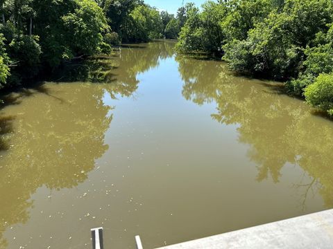 Reedy Fork impounded above the Ossipee Mill Dam, viewed from a bridge, with wooded banks on both sides